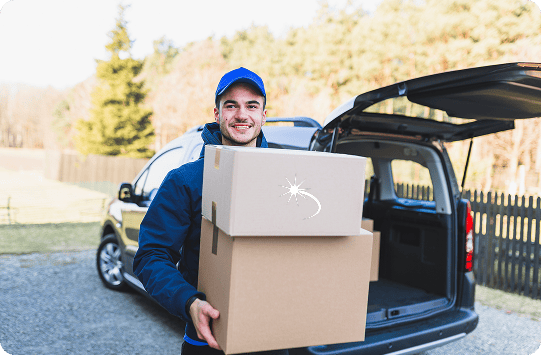A delivery person stands outdoors by a vehicle, holding two cardboard boxes with a white logo and smiling at the camera—representing trusted long distance moving services near me.